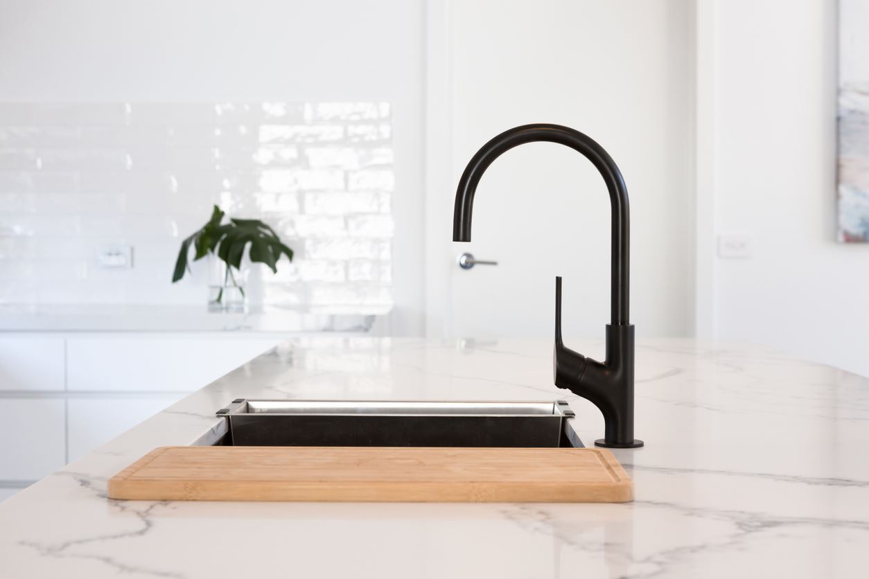 Monochrome kitchen detail of black gooseneck tap Monochrome kitchen detail of black gooseneck tap
