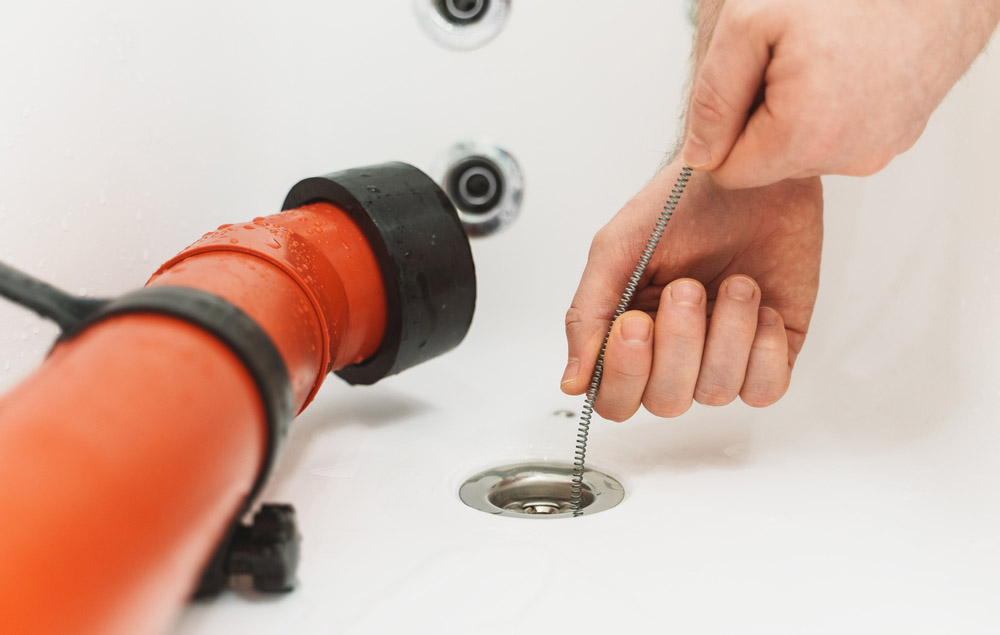 Auger being inserted into a clogged drain