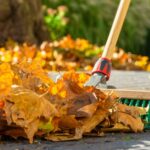 a person sweeping autumn leaves